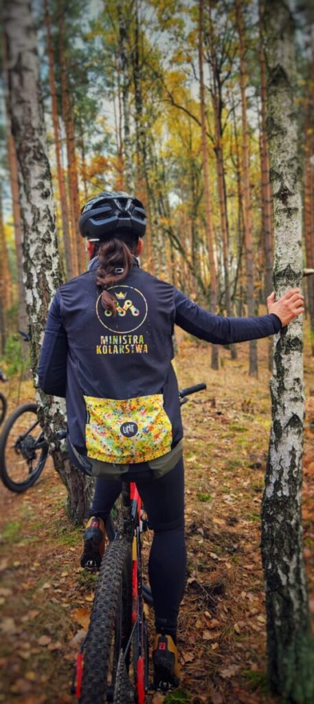 Ministra Kolarstwa w swoich obrandowanych swoim logo ubraniach kolarskich