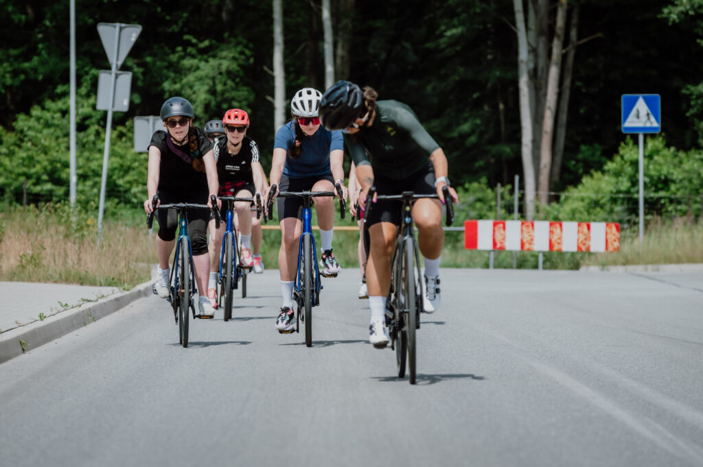 Na zdjęciu widać uczestniczki szkolenia z jazdy w peletonie oraz prowadzącą szkolenie, Ministrę Kolarstwa podczas części praktycznej, już na drodze