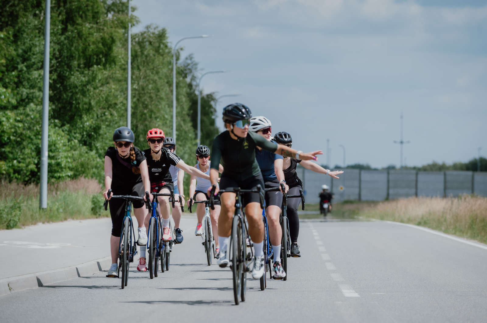 zdjęcie przedstawia grupę początkujących kolarek na szkoleniu Ministry Kolarstwa, które stpsując komunikację kolarską informują o tym, że będą skręcać