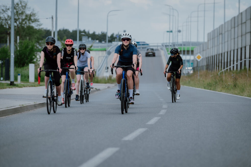 Na zdjęciu widać uczestniczki szkolenia z jazdy w peletonie oraz prowadzącą szkolenie, Ministrę Kolarstwa podczas części praktycznej, już na drodze